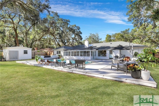 rear view of house with outdoor lounge area, a yard, a wooden deck, and a storage shed