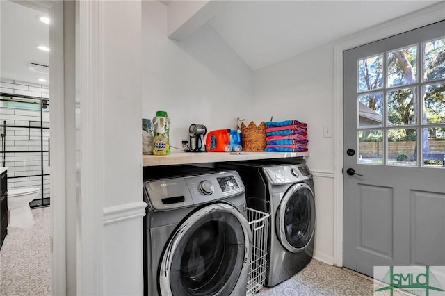 laundry room featuring washer and clothes dryer and light tile patterned floors