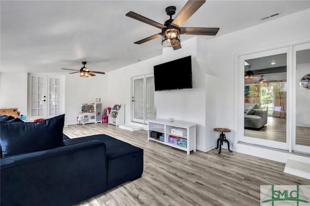 living room with ceiling fan, french doors, and hardwood / wood-style flooring