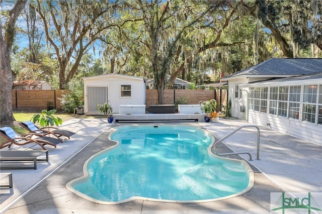 view of swimming pool with a patio area, a jacuzzi, and a storage shed