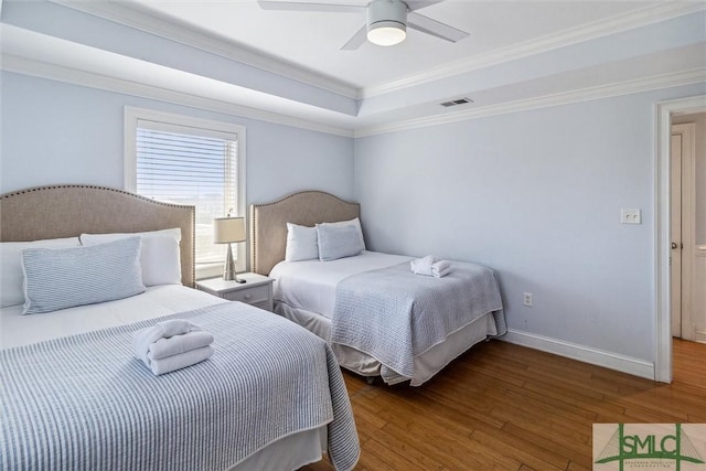 bedroom featuring a raised ceiling, ceiling fan, dark hardwood / wood-style flooring, and ornamental molding