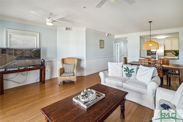 living room with crown molding and light hardwood / wood-style flooring