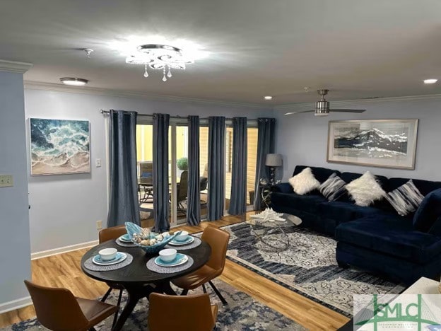 living room with hardwood / wood-style floors, crown molding, and an inviting chandelier