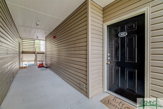 view of exterior entry featuring covered porch