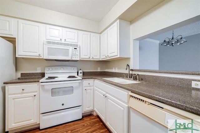 kitchen featuring white appliances, an inviting chandelier, white cabinets, sink, and hanging light fixtures