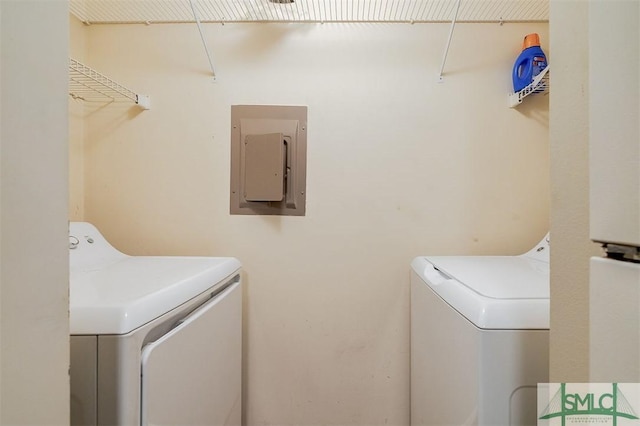 clothes washing area with washer and dryer and electric panel