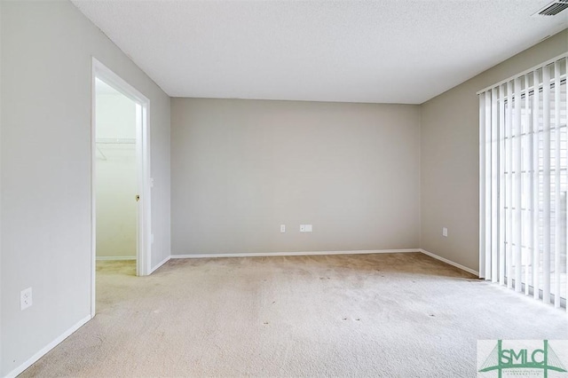 carpeted spare room featuring a textured ceiling