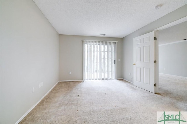 carpeted spare room featuring a textured ceiling