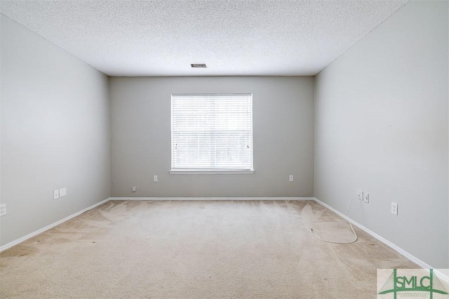 spare room with a textured ceiling and light colored carpet