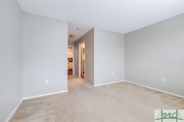 carpeted empty room with a textured ceiling