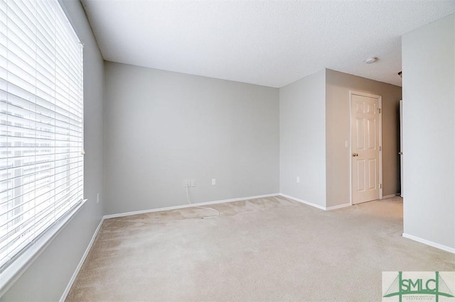 empty room featuring a textured ceiling and light carpet