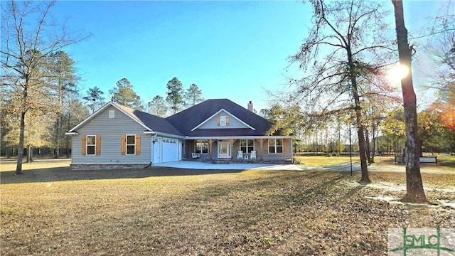 view of front of property with a porch, a garage, and a front lawn