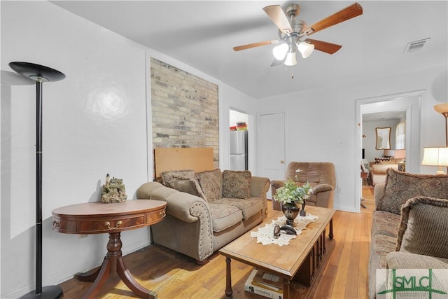 living room with ceiling fan and light hardwood / wood-style flooring