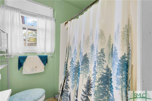 bathroom with curtained shower and toilet