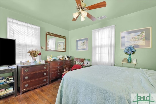 bedroom featuring multiple windows, wood-type flooring, and ceiling fan