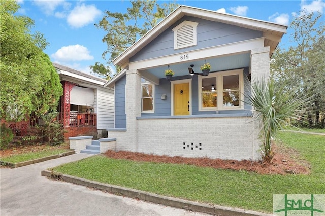 view of front of home featuring covered porch and a front lawn