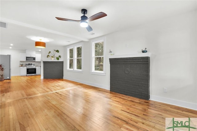 unfurnished living room featuring a fireplace, light hardwood / wood-style flooring, and ceiling fan