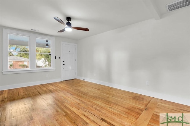 spare room with hardwood / wood-style floors, ceiling fan, and beam ceiling