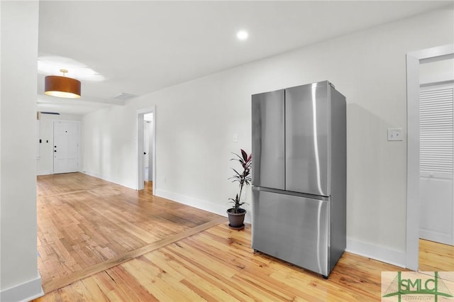 kitchen featuring stainless steel fridge and wood-type flooring