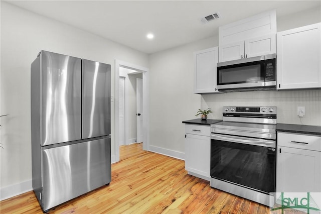 kitchen featuring tasteful backsplash, light hardwood / wood-style flooring, white cabinets, and stainless steel appliances