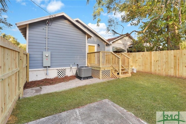 back of house with a wooden deck, a yard, and cooling unit