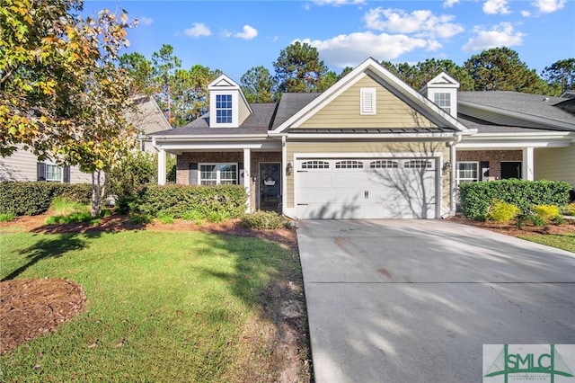 view of front of house featuring driveway, brick siding, an attached garage, and a front lawn