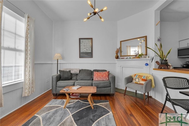 living room with a healthy amount of sunlight, dark hardwood / wood-style floors, and a notable chandelier