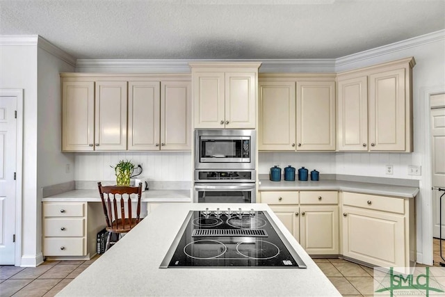 kitchen featuring cream cabinetry, light tile patterned floors, and stainless steel appliances