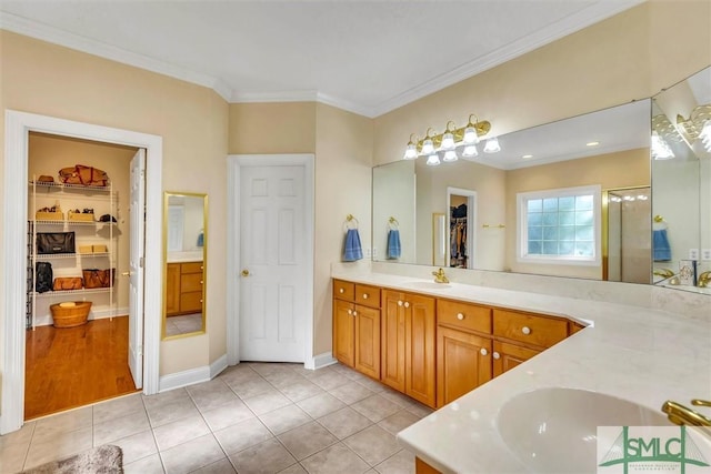 bathroom with crown molding, tile patterned flooring, and vanity