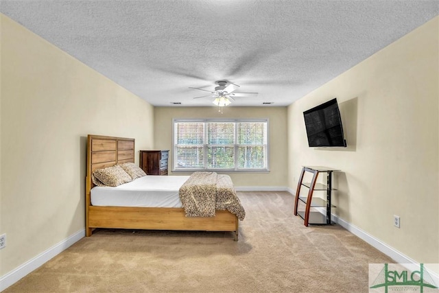 carpeted bedroom featuring a textured ceiling and ceiling fan