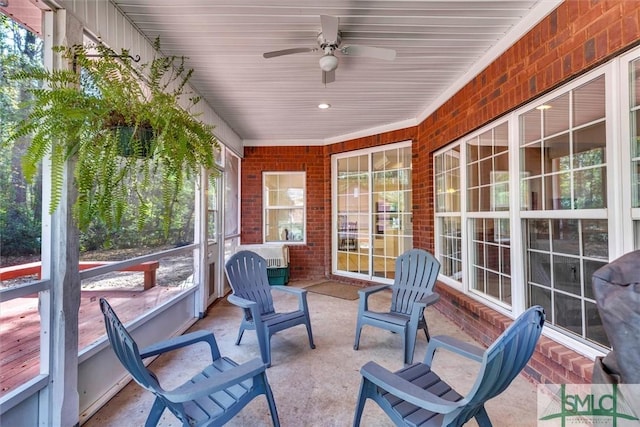 sunroom featuring ceiling fan and plenty of natural light