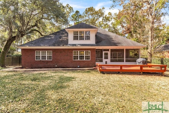 back of house featuring a lawn, a sunroom, and a deck