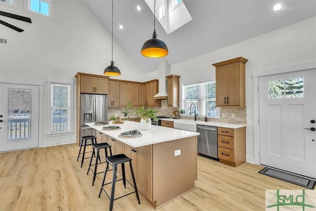 kitchen with stainless steel appliances, a center island, tasteful backsplash, custom exhaust hood, and pendant lighting