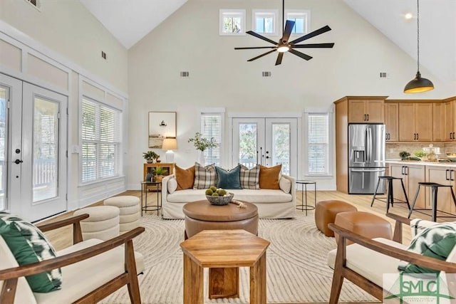 living room with french doors, high vaulted ceiling, and plenty of natural light