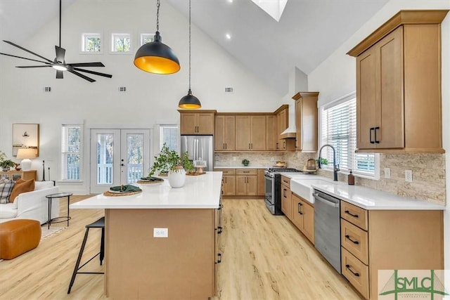 kitchen with stainless steel appliances, sink, a center island, decorative backsplash, and high vaulted ceiling