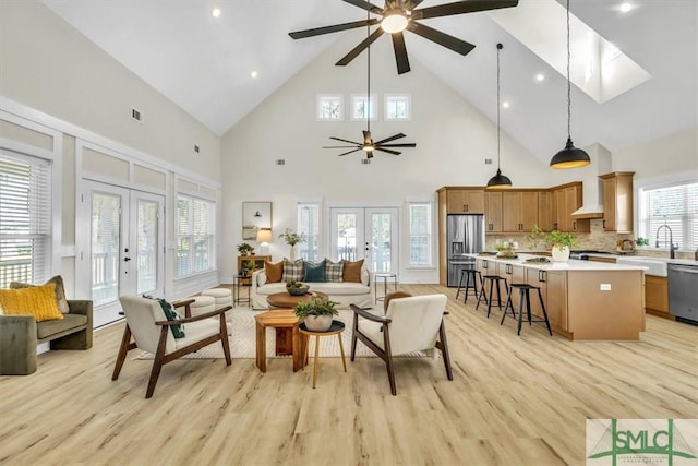 living room with light hardwood / wood-style flooring, french doors, and high vaulted ceiling