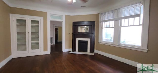 unfurnished living room with dark hardwood / wood-style flooring and ceiling fan