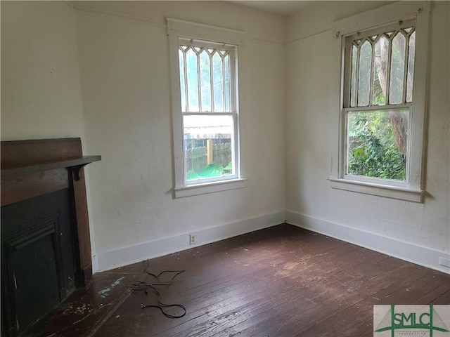 unfurnished living room featuring a fireplace and dark hardwood / wood-style floors