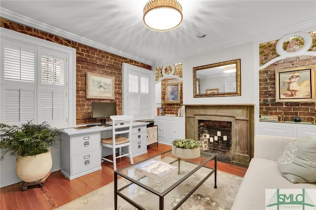 living area featuring crown molding, brick wall, and light hardwood / wood-style flooring