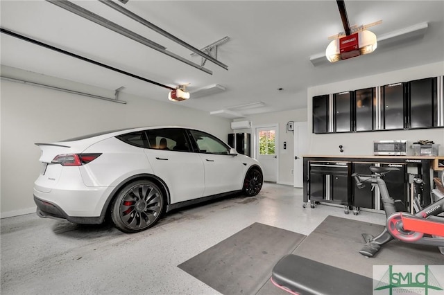 garage with a garage door opener and a wall mounted AC