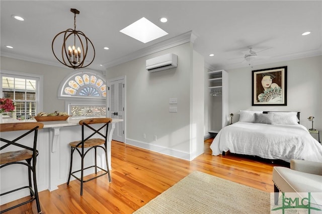 bedroom with crown molding, a wall unit AC, and light hardwood / wood-style flooring