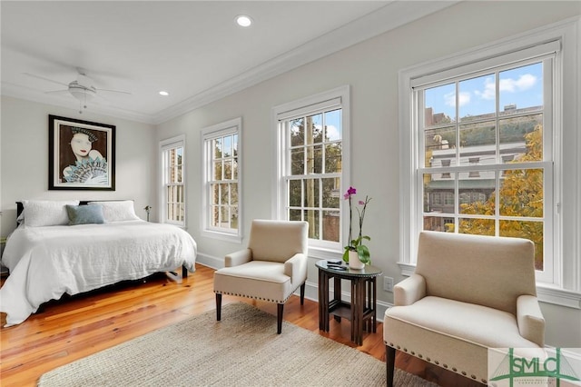 bedroom with hardwood / wood-style floors, ceiling fan, and ornamental molding