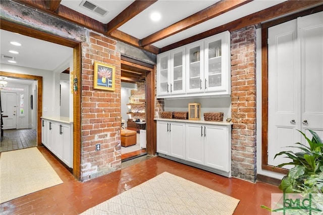 bar with white cabinets and beamed ceiling