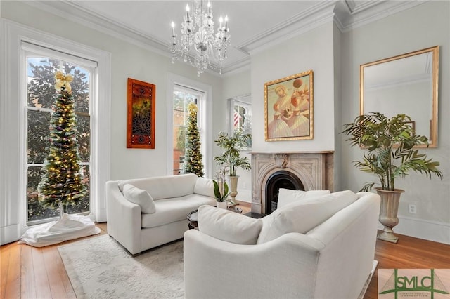 living room with light hardwood / wood-style floors, crown molding, and a chandelier