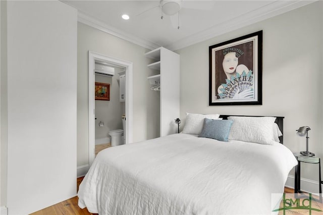 bedroom with crown molding, ceiling fan, connected bathroom, a wall mounted AC, and light hardwood / wood-style floors