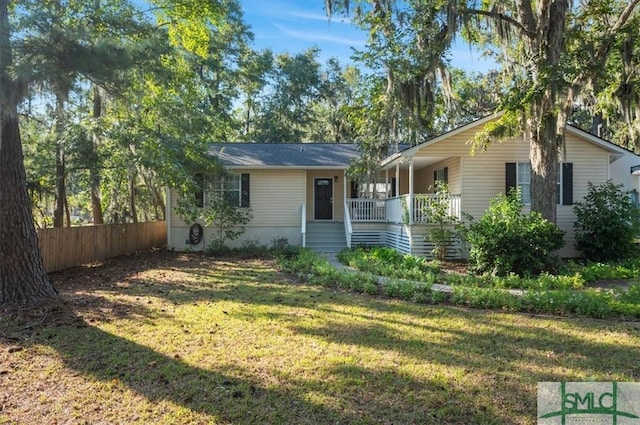 ranch-style home featuring covered porch and a front lawn