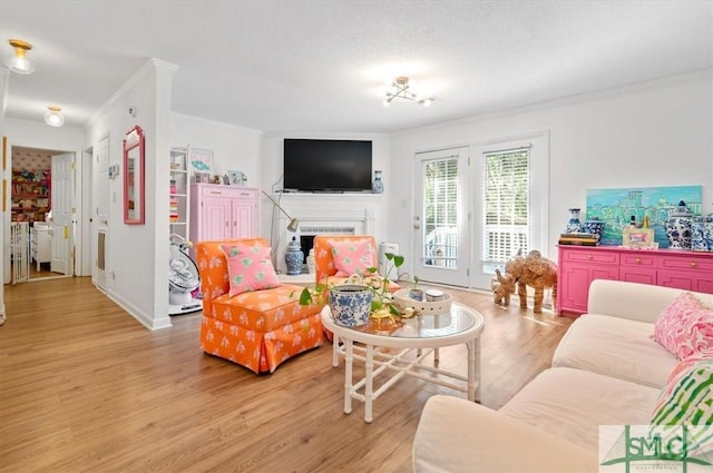 living room featuring crown molding, light hardwood / wood-style floors, and a textured ceiling