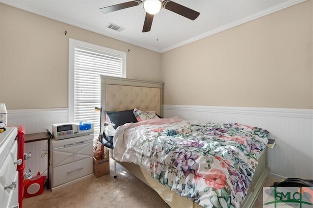 carpeted bedroom featuring ceiling fan and ornamental molding