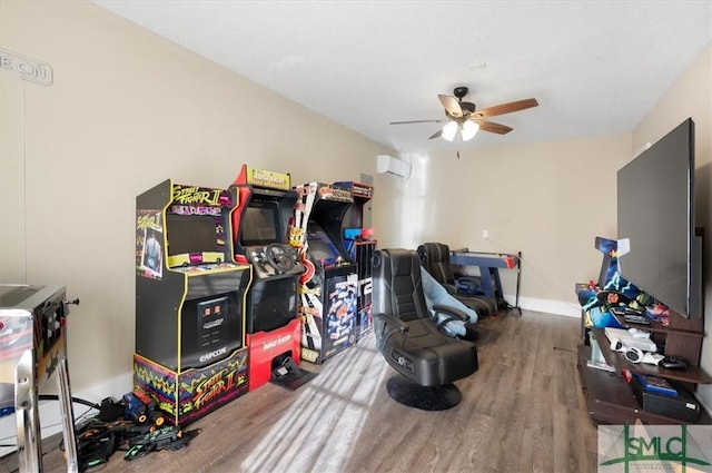 playroom with hardwood / wood-style floors, ceiling fan, and a wall mounted AC