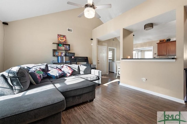 living room featuring ceiling fan, dark wood-type flooring, and vaulted ceiling